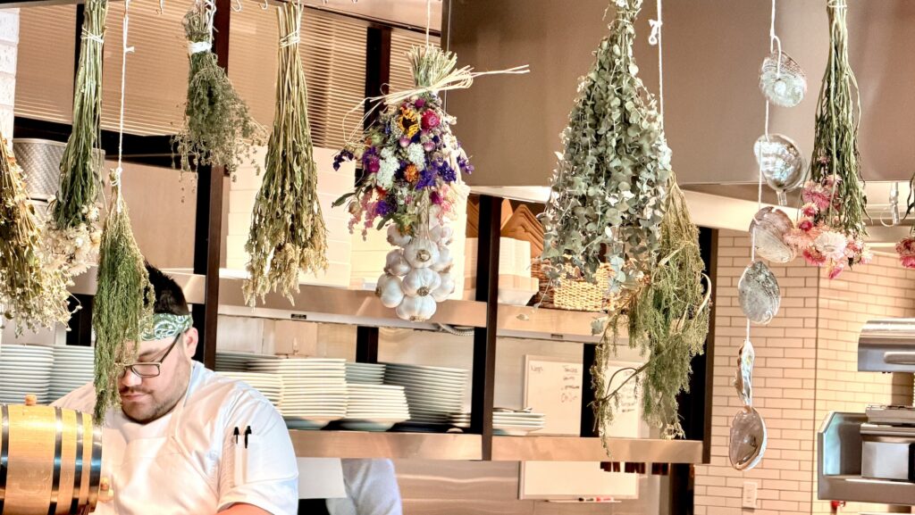 flowers and herbs drying in the open kitchen at Folia, the restaurant at Appellation Healdsburg