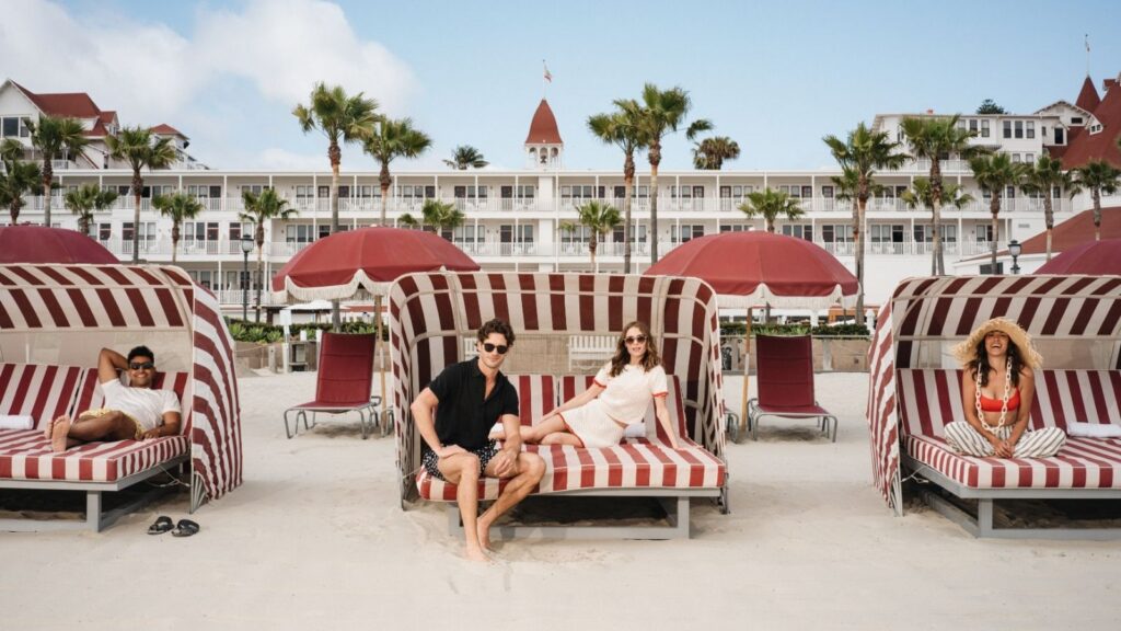 Couple on a striped red beach daybed at Hotel del Coronado in San Diego California