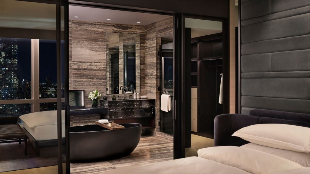 evening in a room at the Equinox Hotel in NYC with view of bed and bathtub
