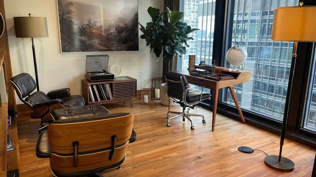 view of a room at the Langham in Chicago with midcentury modern furniture and a view of the city