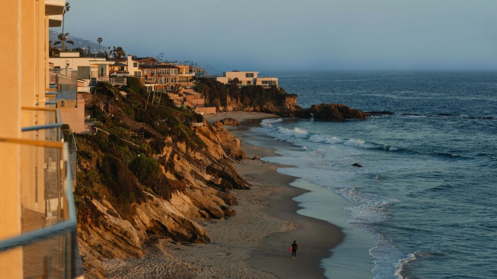 A surfer walking on the beach at Surf & Sand Laguna Beach