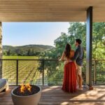 A couple on a balcony overlooking at vineyard at Alila Napa Valley