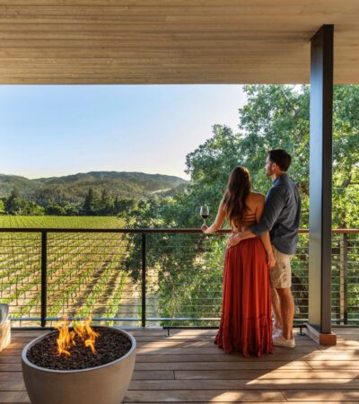 A couple on a balcony overlooking at vineyard at Alila Napa Valley