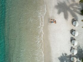 aerial view of couple on white-sand beach with aquamarine water at Sugar Beach resort in St. Lucia